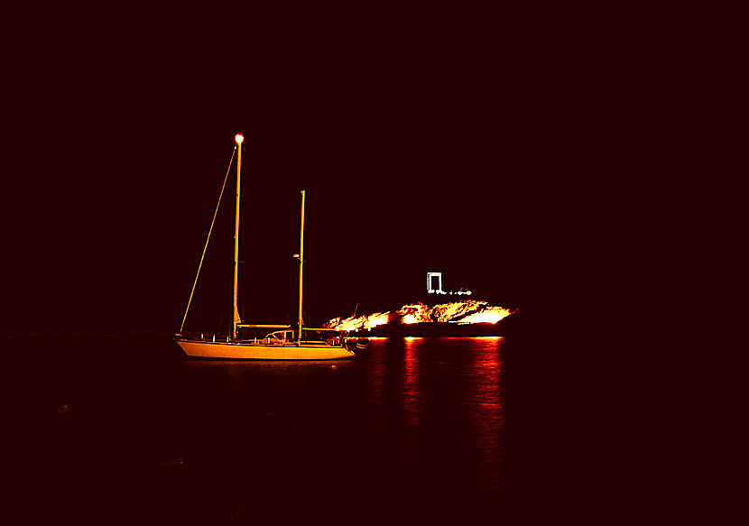 En segelbåt i havet utanför Portaran i Naxos stad på kvällen.