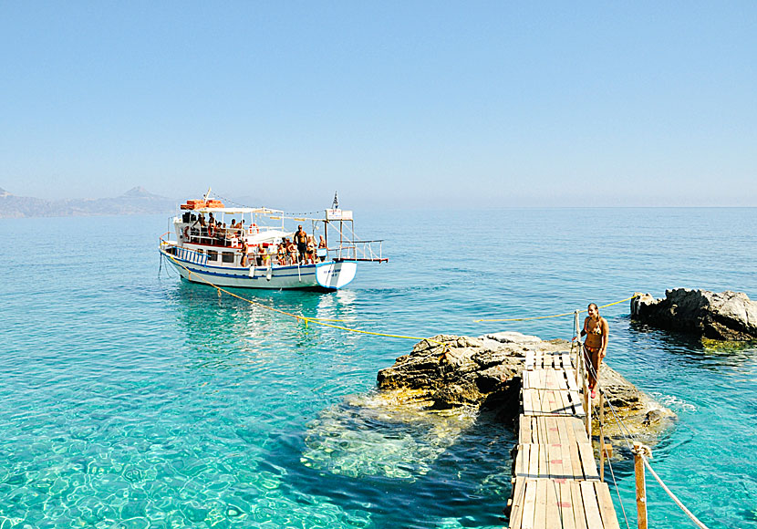 Bad- och utflyktsbåtar vid Kato Lakos beach på Karpathos i Grekland. 